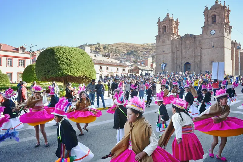 Dançarinas com trajes coloridos em festa folclórica diante da Catedral de Puno